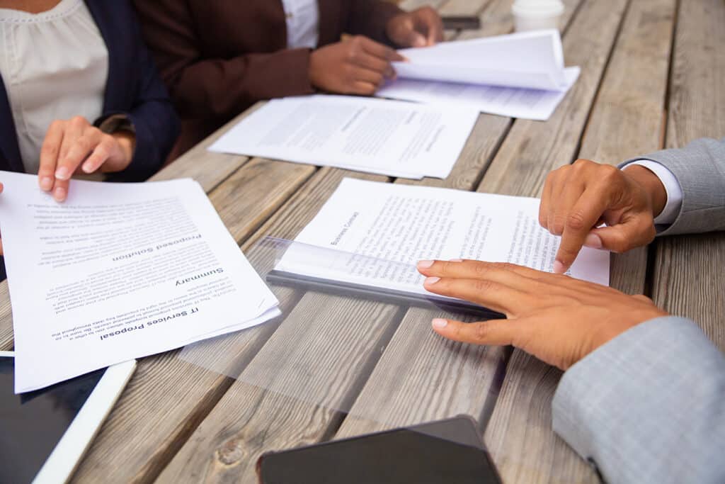Personnes examinant les clauses d’un contrat autour d’une table